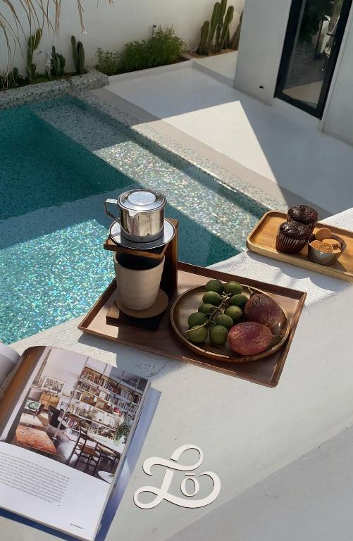 una bandeja de comida en una mesa junto a una piscina en Lo Villa Phu Yen, en Phú Hiệp