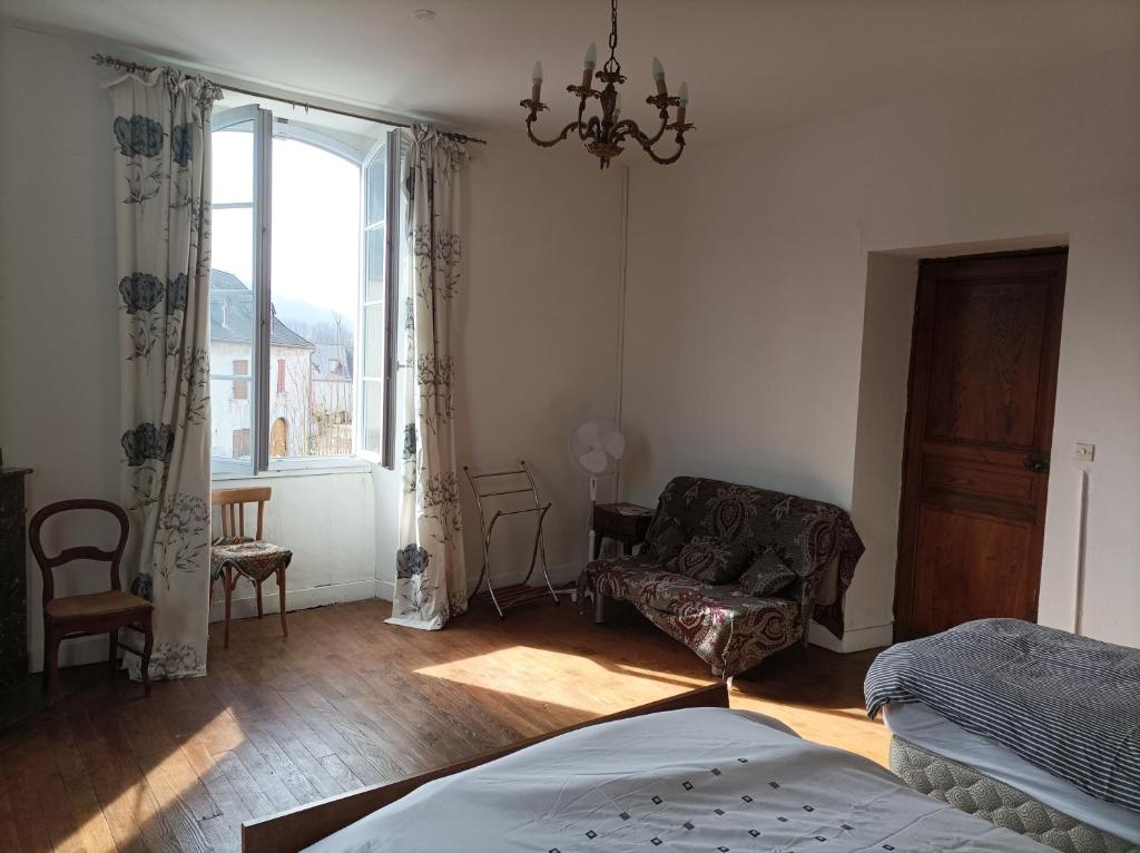 a bedroom with a bed and a chair and a window at Chez Susan in Buzy