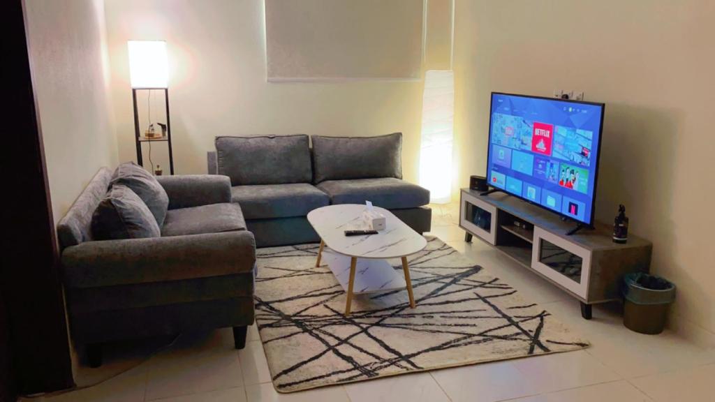 sala de estar con sofá y TV en شقة بغرفه نوم وصالة, en Az Zulfi
