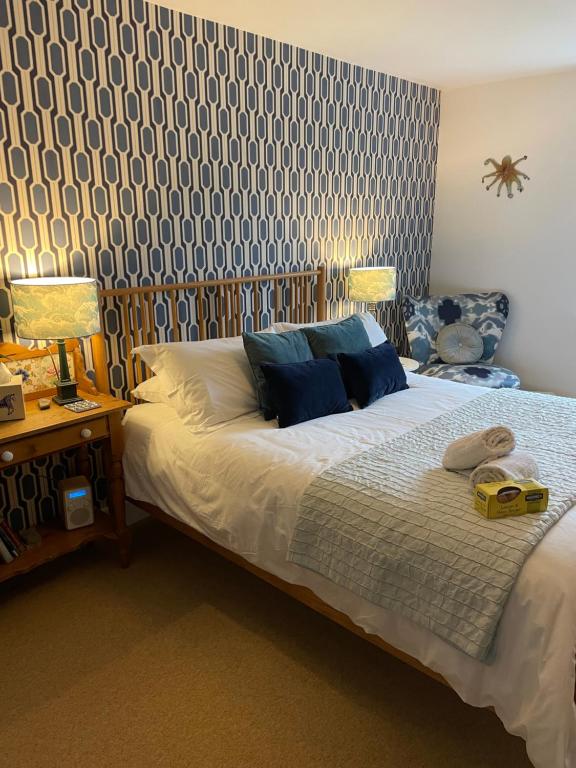 1 dormitorio con 1 cama con papel pintado azul y blanco en No 12 en Lyme Regis