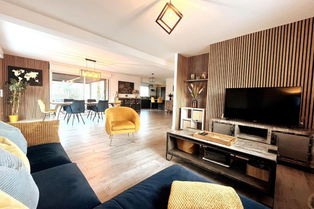 ein Wohnzimmer mit einem Sofa und einem Flachbild-TV in der Unterkunft La Prestigieuse - MALO’Cation in Leffrinckoucke
