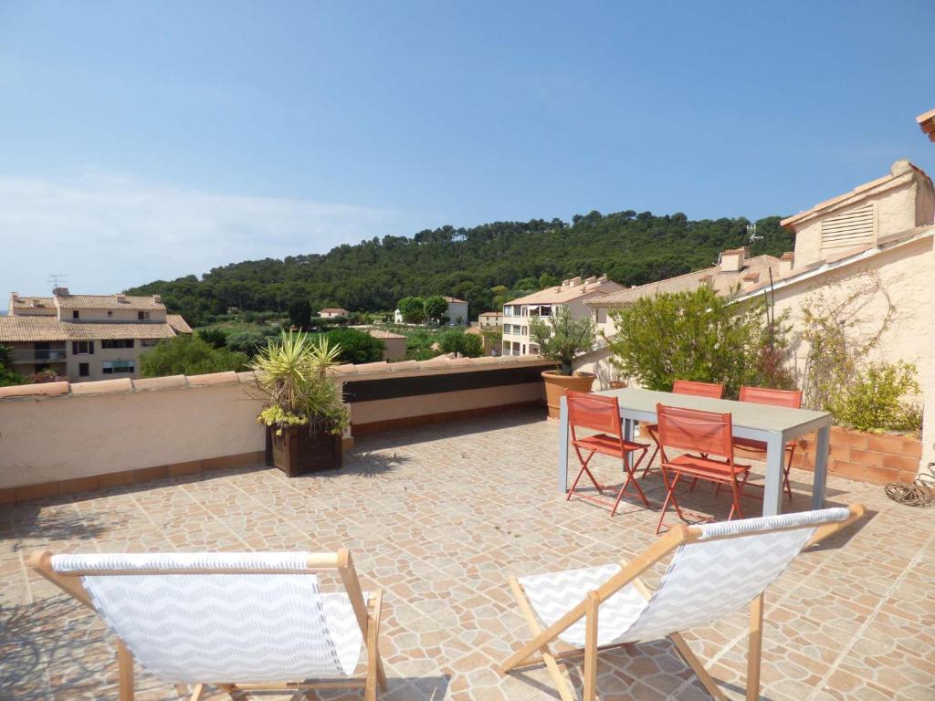 un patio avec des chaises et une table sur un toit dans l'établissement 2 Chambres avec Grande terrasse de 25m² à 350M de la Plage, à Saint-Mandrier-sur-Mer