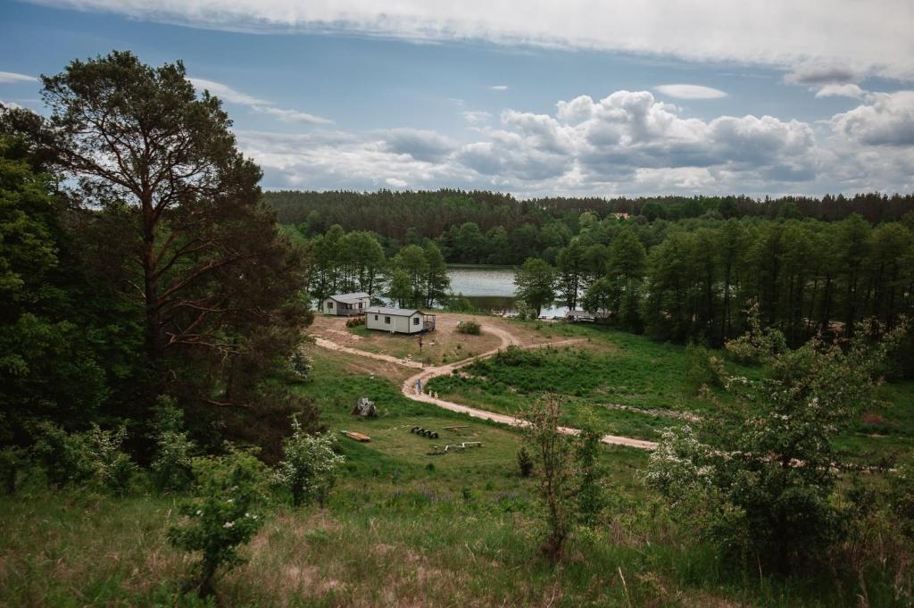 a view of a campsite in a field next to a lake at Siedlisko13 in Mrągowo