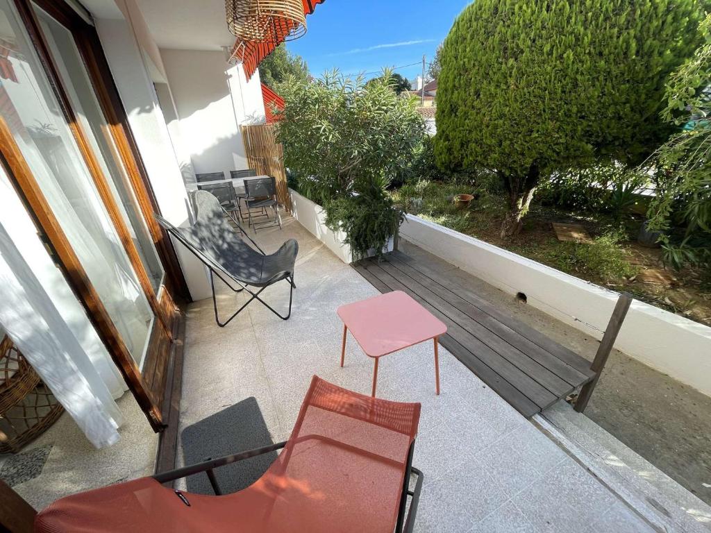 d'une terrasse avec des chaises et une table rose sur un balcon. dans l'établissement Appartement lumineux à deux pas de la plage, tout équipé et tout à pied !, à La Seyne-sur-Mer