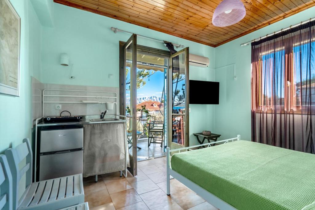 a bedroom with a bed and a kitchen and a balcony at Old Boat double studio 11 in Nikiana