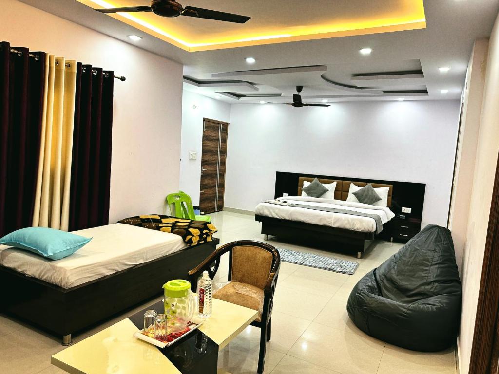 a living room with two beds and a couch at Hotel Pink Paradise in Gorakhpur