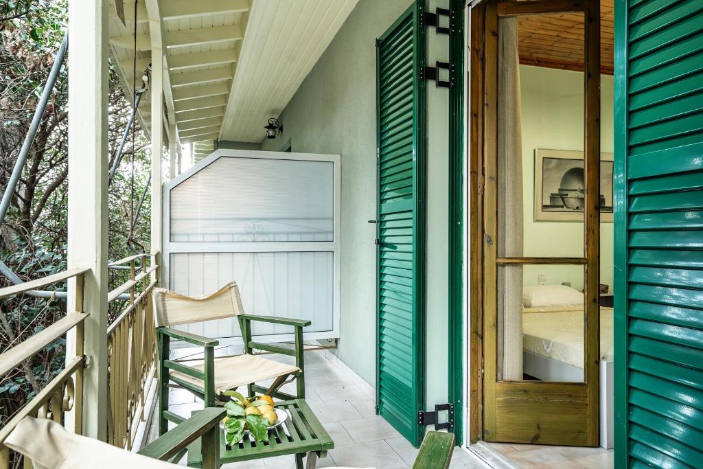 a porch with a chair and a bed at Old Boat double studio 8 in Nikiana