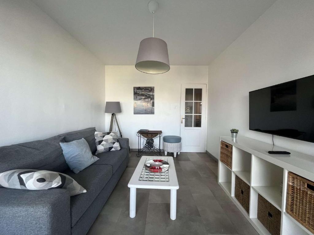 een woonkamer met een bank en een tafel bij Appartement 2 chambres, climatisation, vue mer, refait à neuf en 2020 in Saint-Mandrier-sur-Mer