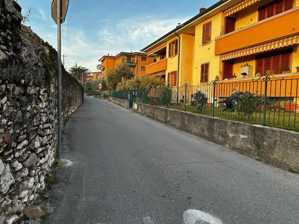 una calle vacía junto a una pared de piedra en Casa Gabriel, en Toscolano Maderno