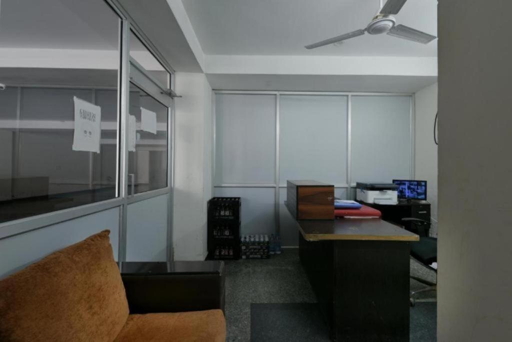 - un bureau avec un canapé, un bureau et un ventilateur de plafond dans l'établissement Hotel Olive Saffron at Rohini, à New Delhi