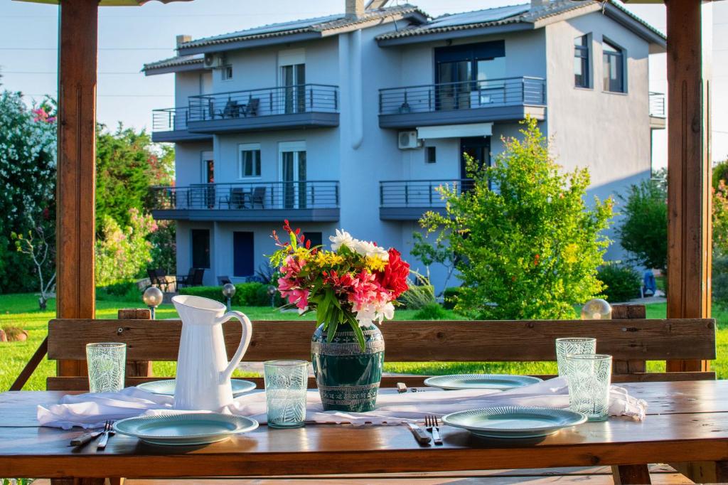 a wooden table with a vase of flowers on it at Villa Orama in Nea Potidaea