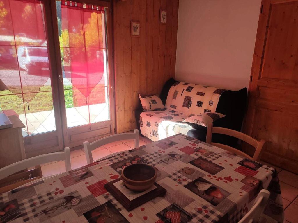 a room with a table with a quilt on it at Chalets D Or - 2 Pièces pour 4 Personnes 164 in Vénosc