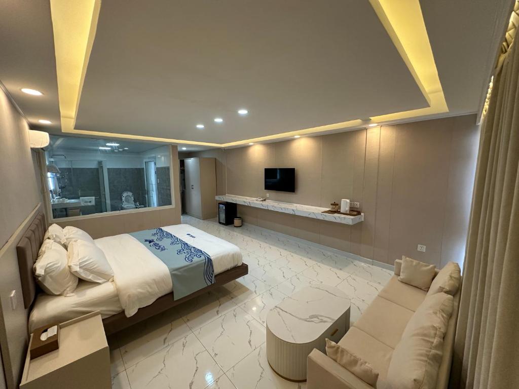 - une grande chambre avec un lit et un canapé dans l'établissement Luckytito Anilao Resort, à Mabini