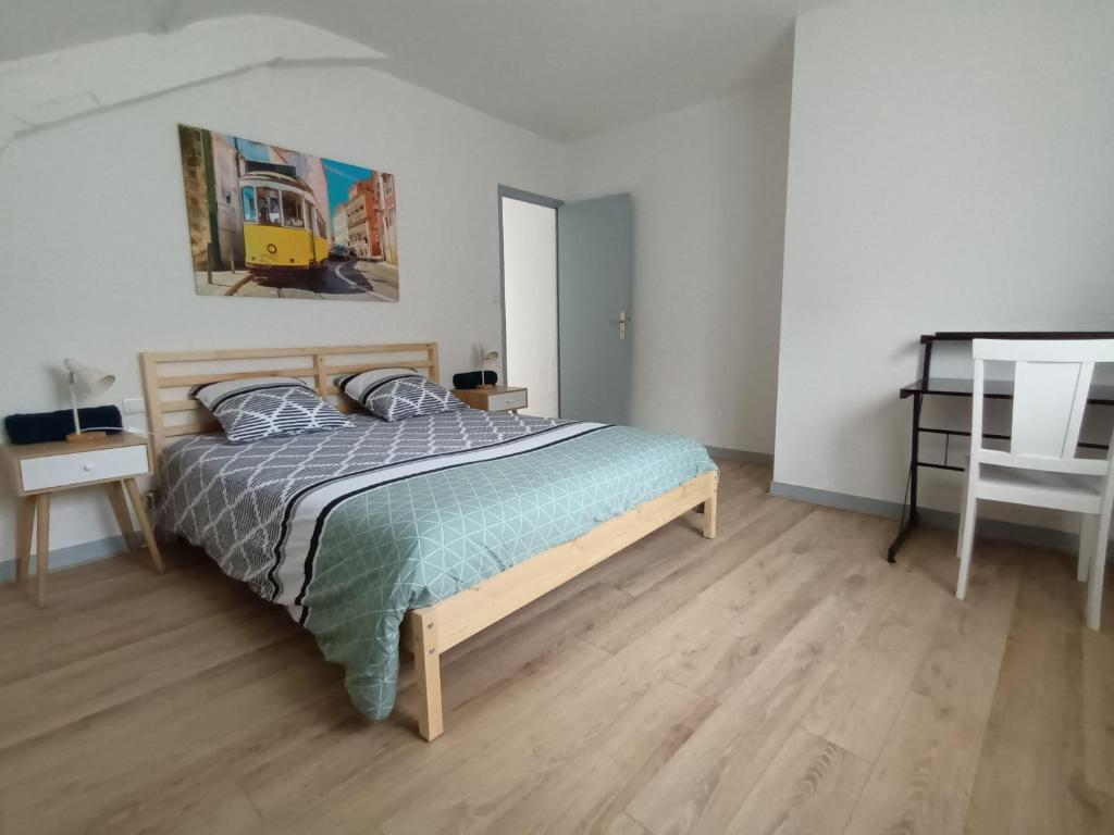 Schlafzimmer mit einem Bett und Holzboden in der Unterkunft immeuble entier ✰ coeur de ville ✰ terrasse balcon in Segré