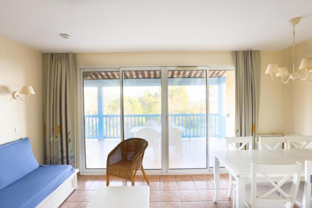 un salon avec un canapé bleu et une table dans l'établissement Résidence le Hameau des Issambres - maeva Home - 2 Pièces 6 Personnes Sélection MAE-1296, aux Issambres