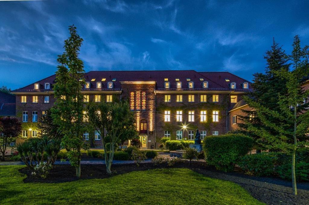 a large building with lights on in a yard at Haus Overbach in Barmen