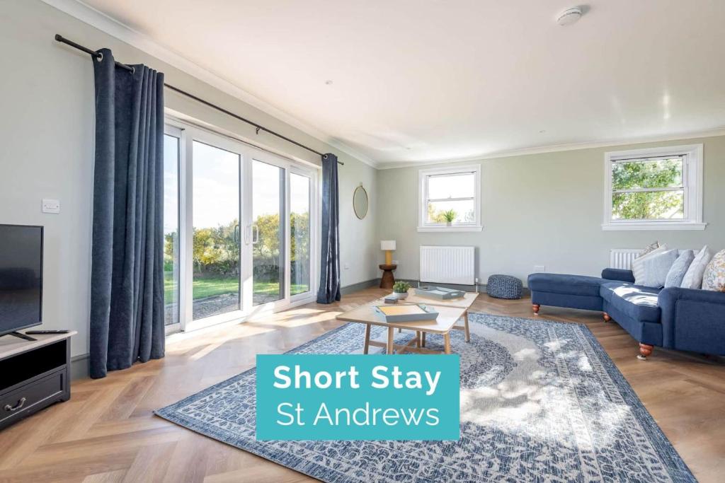 a living room with a couch and a tv at Firthview - Crail in Anstruther