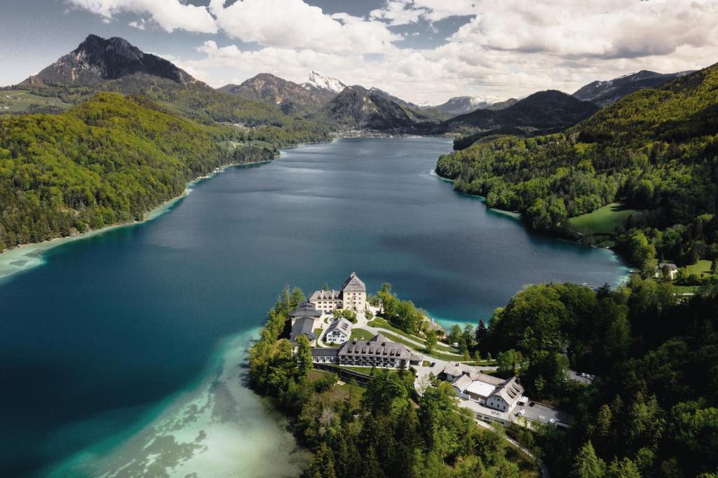 uma vista aérea de uma mansão numa ilha num lago em Rosewood Schloss Fuschl em Hof bei Salzburg