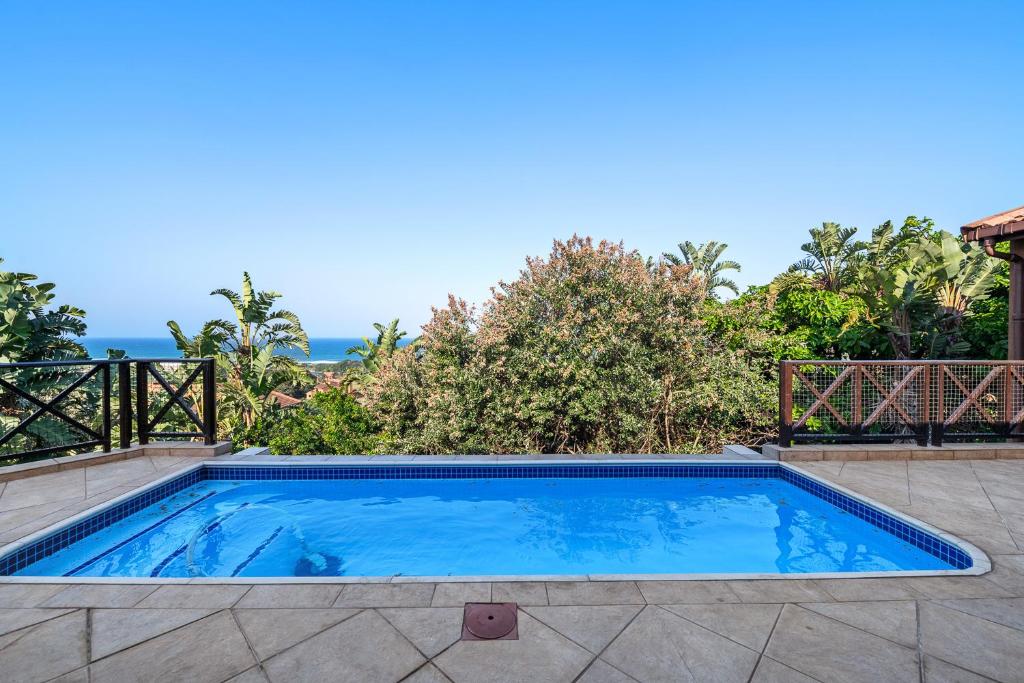 uma piscina com água azul num quintal em San Lameer Villa - 14328 - 4 Bedroom Deluxe - 8 pax - San Lameer Rental Agency em Southbroom