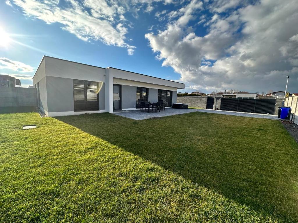 a large yard with a white building on a roof at Klimatizovaný Apartmánový dom s vírivkou, 9A in Senec