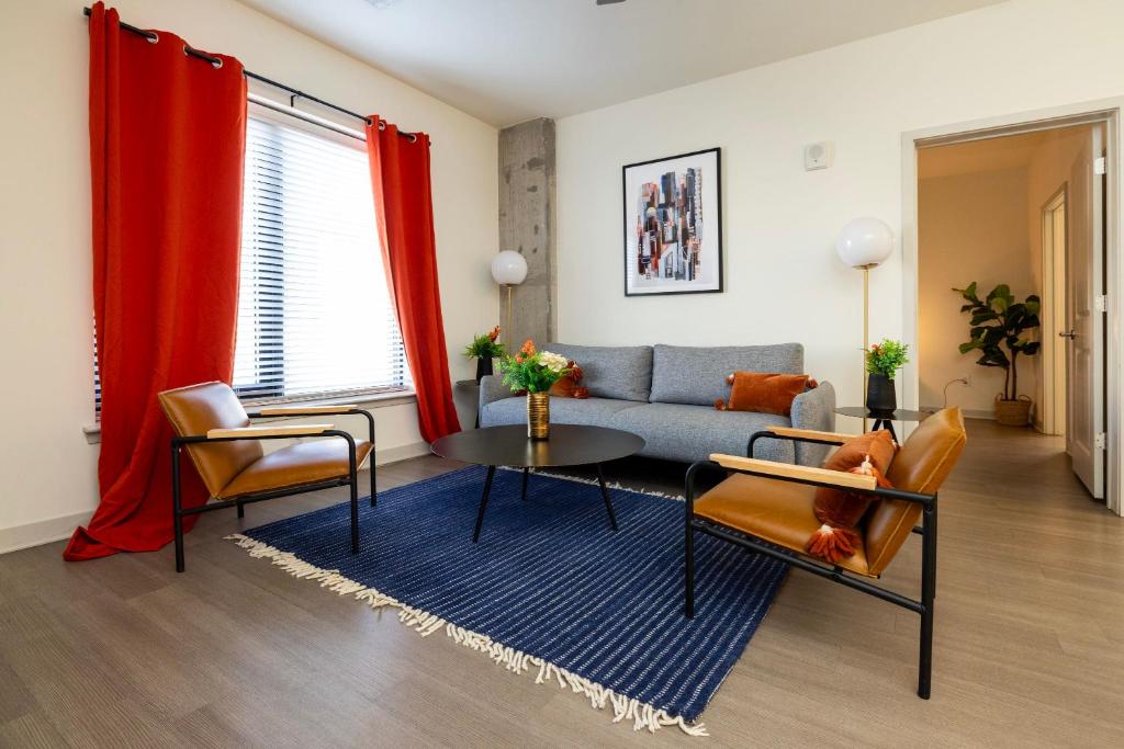 a living room with a couch and a table and chairs at Modern Nulu 2BR CozySuites Unit 03 in Louisville