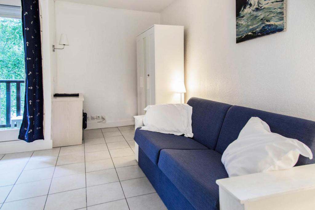 salon z niebieską kanapą z 2 poduszkami w obiekcie Résidence Les Embruns - maeva Home - Studio 4 Personnes Confort MAE-1715 w mieście Deauville