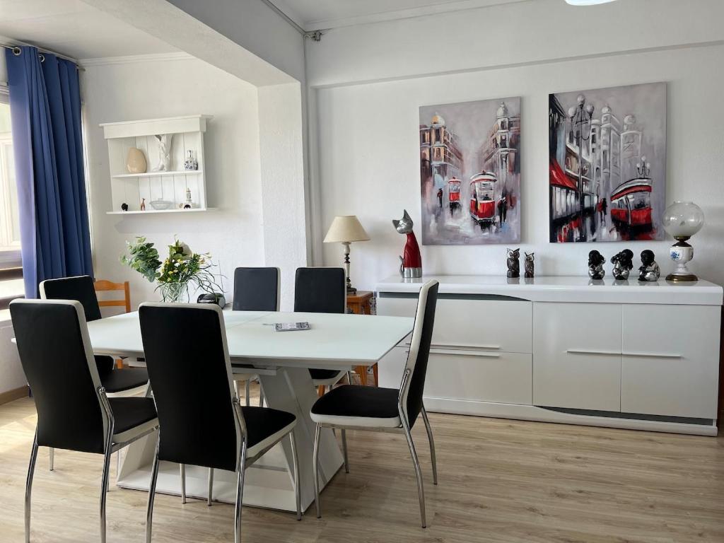 a dining room with a white table and chairs at 2 Bedroom apartment in Caparica by the beach in Costa da Caparica