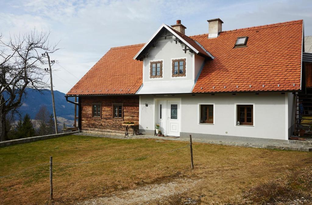 Biały dom z pomarańczowym dachem w obiekcie Ski Lodge Peneze w mieście Vitanje