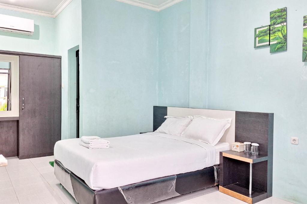 - une chambre avec un grand lit et des draps blancs dans l'établissement Homestay Dalimo 2 Syariah RedPartner, à Payakumbuh