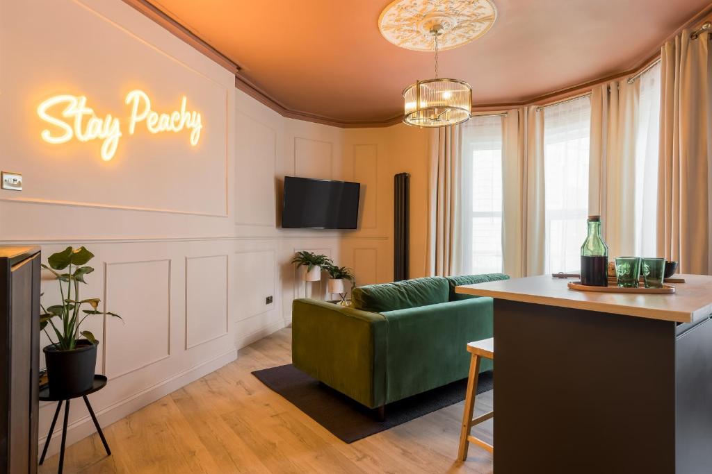 uma sala de estar com um sofá verde e um cartaz que diz "fique polido" em Stylish Central Apartment em Bournemouth