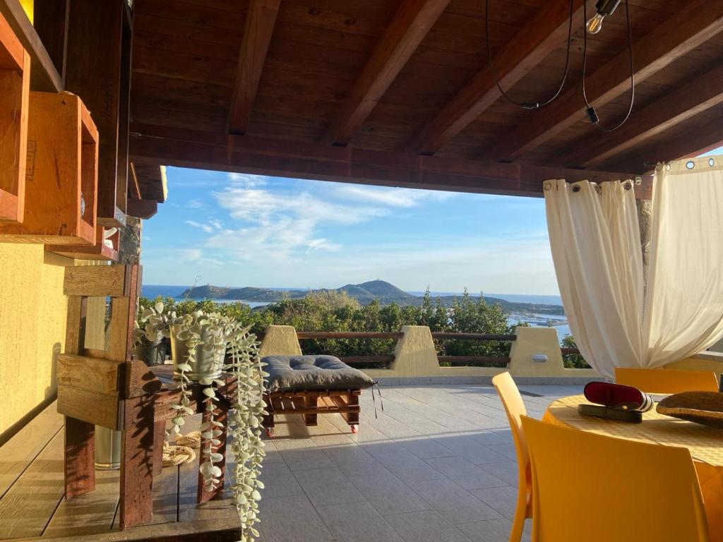 Elle offre une vue sur une terrasse avec une table et des chaises. dans l'établissement Casa panoramica Villasimius, à Villasimius