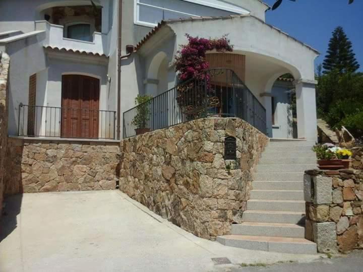 uma casa com uma parede de pedra e escadas em frente em CASA LU DO' em Agrustos