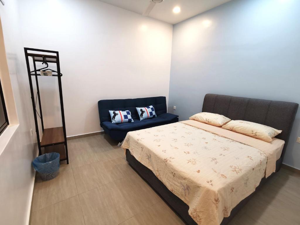 1 dormitorio con 1 cama y 1 silla azul en Amuse Homestay at Kuala Kubu Bharu en Kuala Kubu Baharu