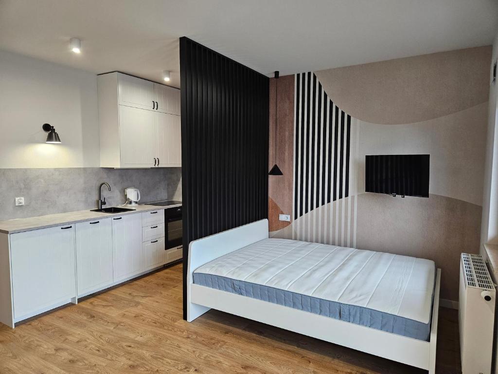 een kleine slaapkamer met een bed en een keuken bij Apartamenty Orawska 14 in Krakau