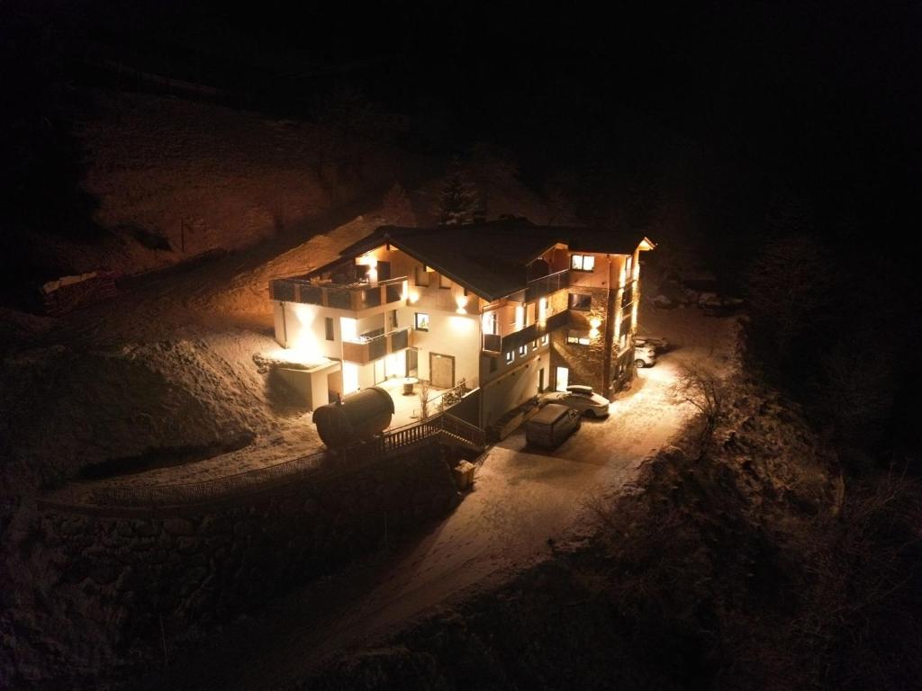 une maison éclairée la nuit avec des lumières allumées dans l'établissement Landhaus Oberzinnegg, à Saalbach-Hinterglemm