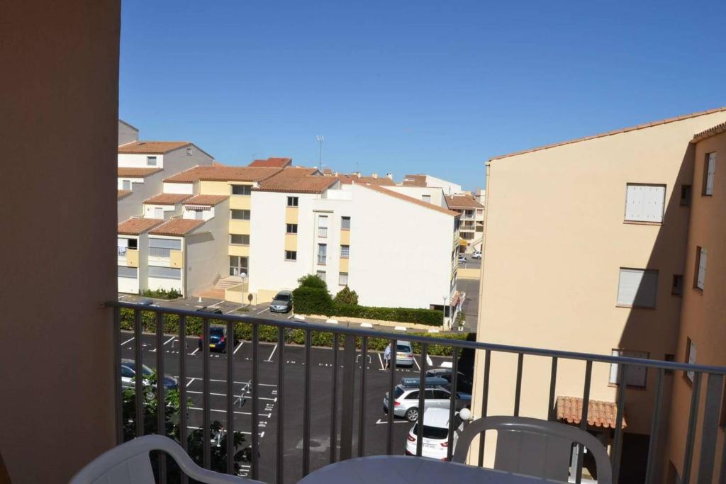 d'un balcon avec vue sur une rue et des bâtiments. dans l'établissement 031 Palmeraie Studio avec parking plage du môle, au Cap d'Agde