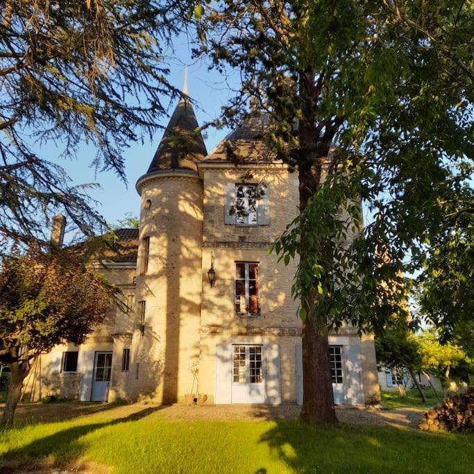 un vieux bâtiment en pierre avec un arbre en face de lui dans l'établissement Gite au château, à Castelnau-sur-Gupie