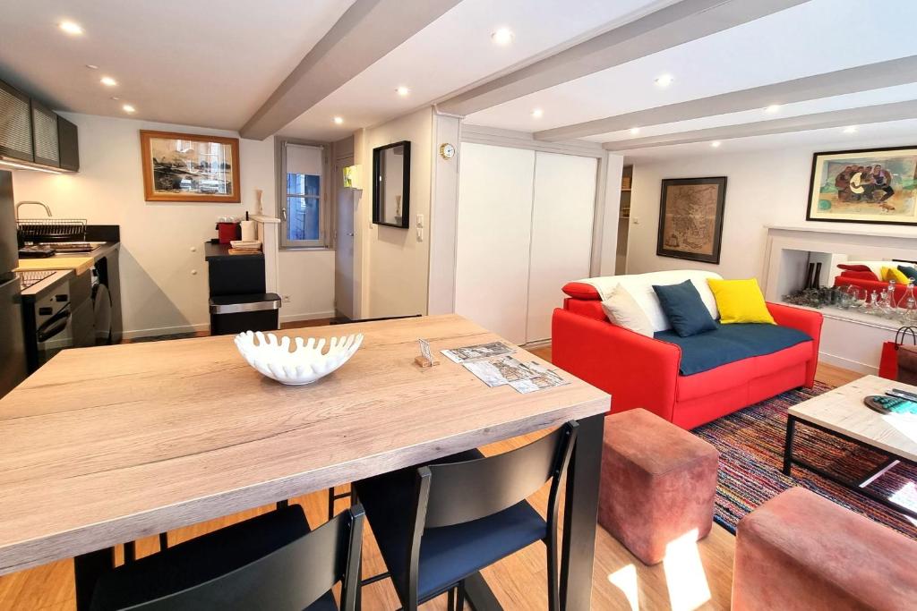 cocina y sala de estar con mesa y sofá rojo en Le Repère de Popeye - nice apartment with 1 bedroom - Honfleur Center - 4p en Honfleur
