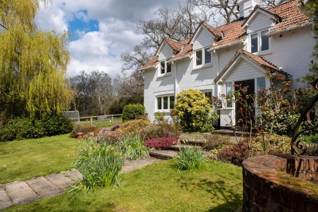柏利的住宿－Bramble Cottage，庭院内带花园的白色房子