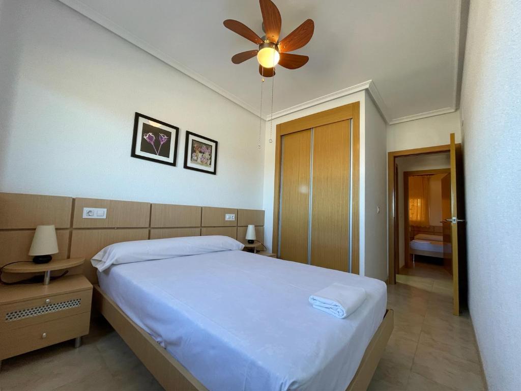 a bedroom with a bed and a ceiling fan at Apartamentos Costamar 3000 in Torre de la Sal