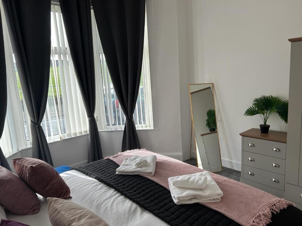 a bedroom with a bed with two towels on it at Bute Apartment by Klass Living Coatbridge in Coatbridge