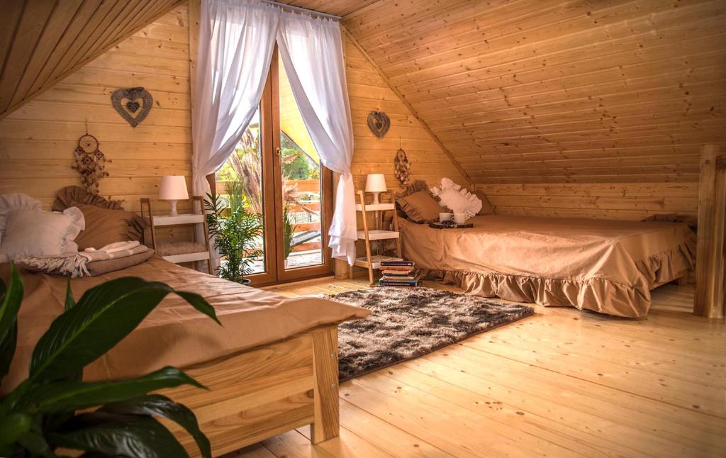 a bedroom with two beds in a log cabin at DOMEK KARMELOWY - Azyl Na Szwedach in Ruszelczyce