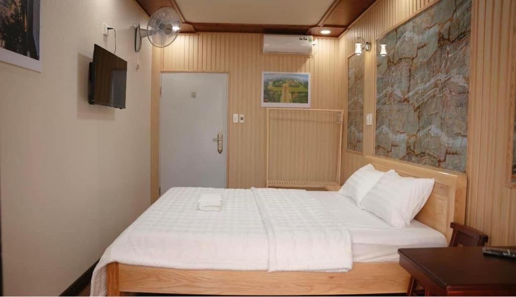 1 dormitorio con 1 cama blanca grande en una habitación en Motel Ngọc Hiền, en Pleiku