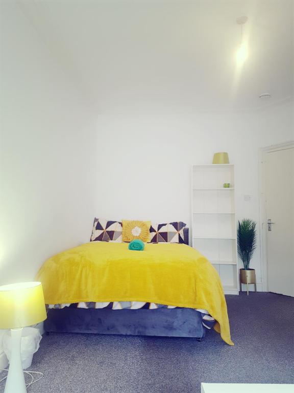 Double Room Close To Headingley Stadium Leeds في ليدز: غرفة نوم بسرير وبطانية صفراء