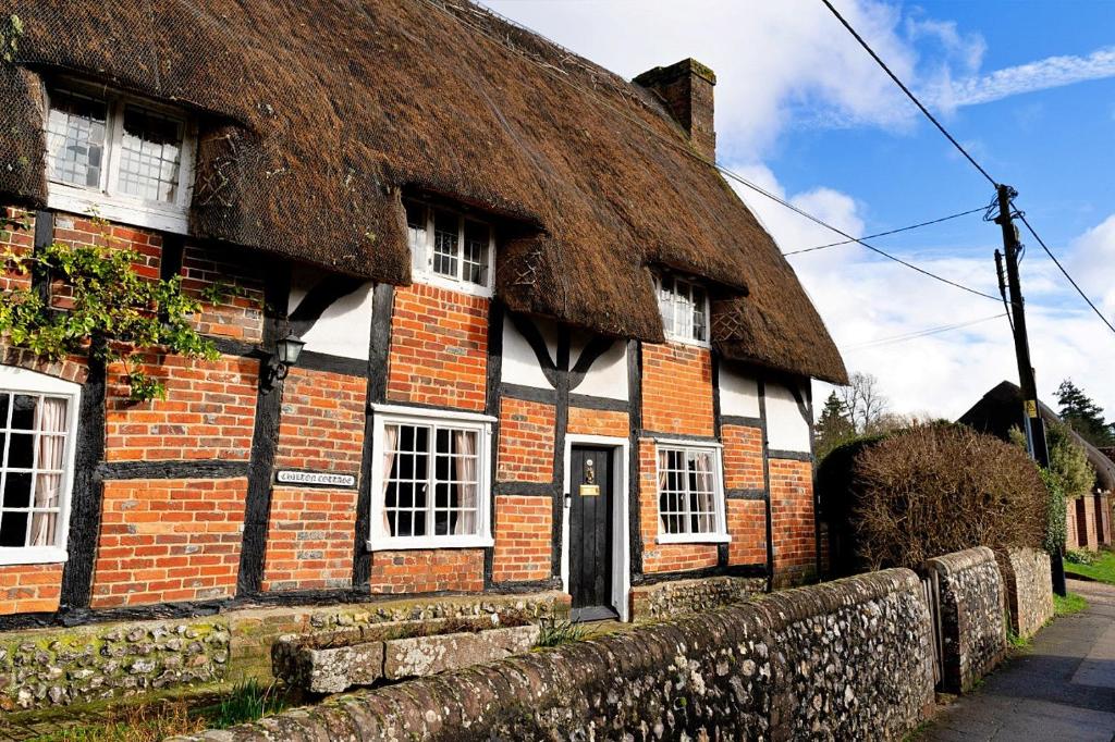 een oud bakstenen gebouw met een rieten dak bij Finest Retreats - Chilton Cottage in Hungerford