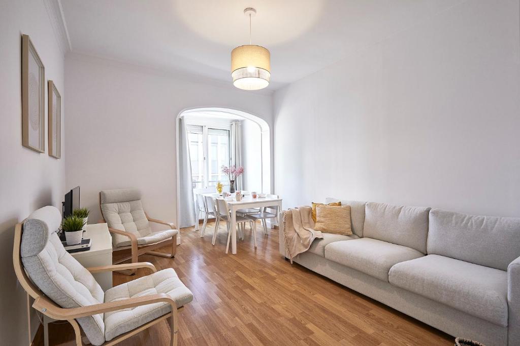 - un salon avec un canapé et une table dans l'établissement BBarcelona Central Eixample Flat, à Barcelone