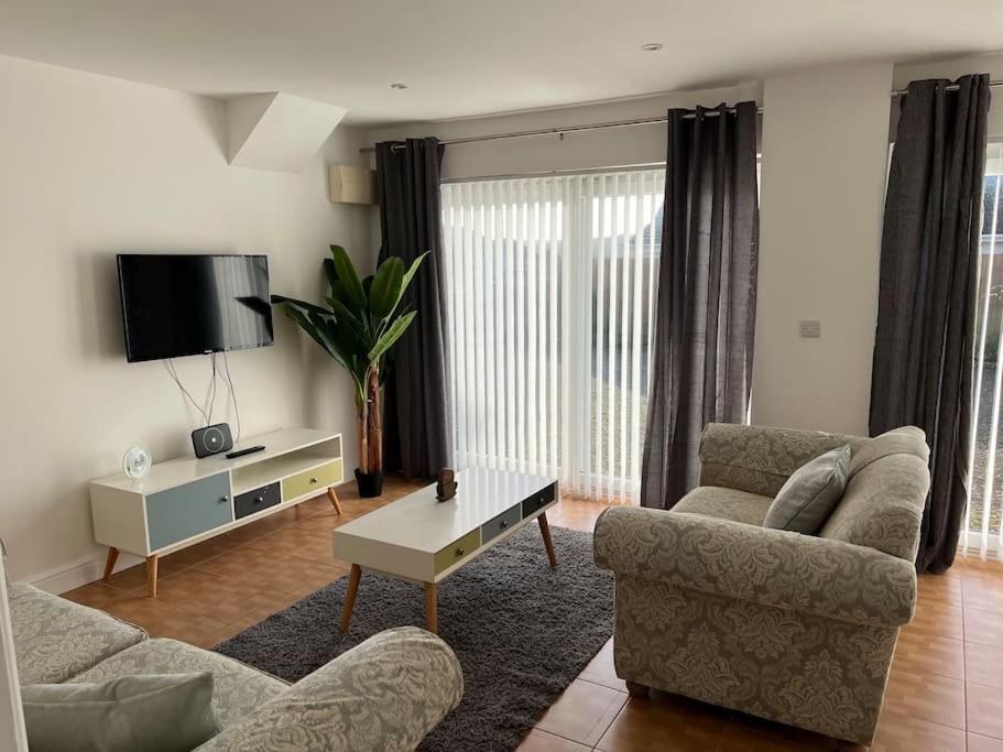 a living room with two chairs and a tv at Maple House a spacious 2 Bedroom House in Barnstaple