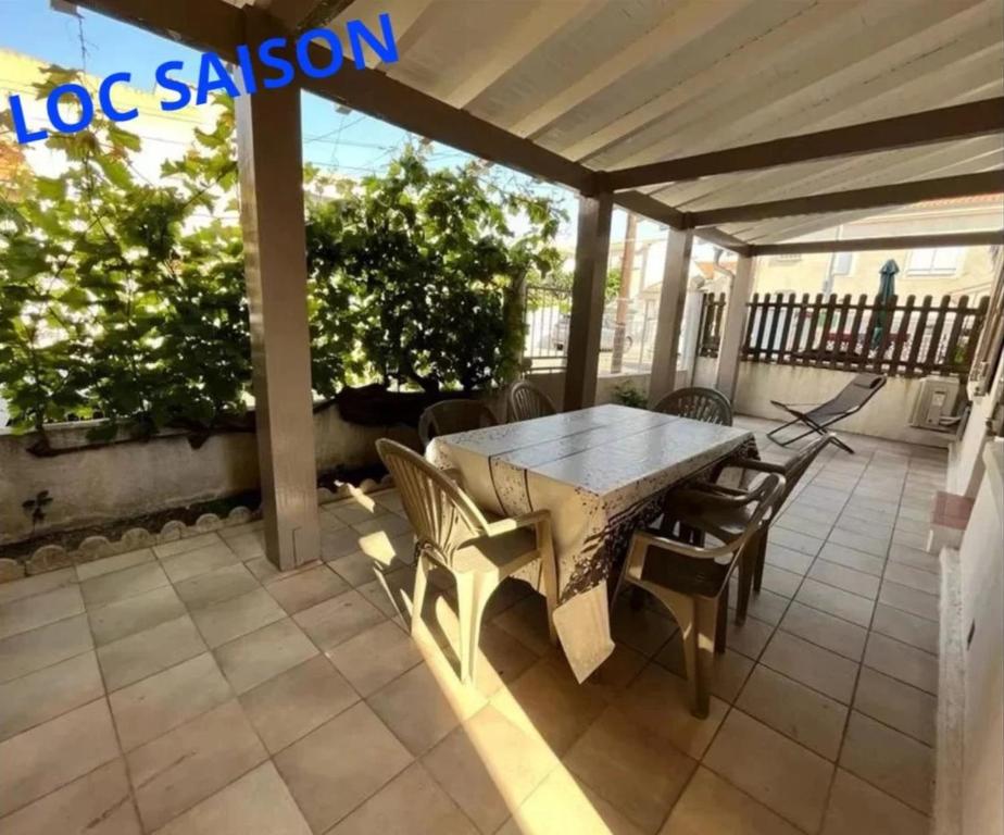 un patio avec une table et des chaises sur un porche dans l'établissement Moli Pêcheur, à Valras-Plage