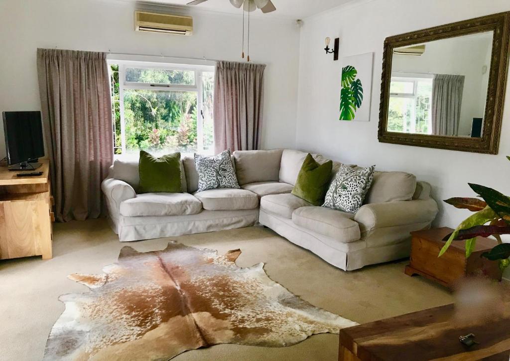 ein Wohnzimmer mit einem Sofa und einem Spiegel in der Unterkunft Sagelands for business travel & family getaways in Durban