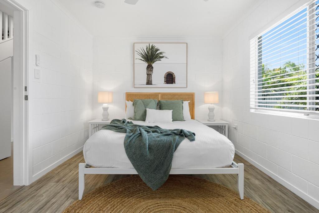 Habitación blanca con cama y ventana en Charming 5-Bed Coastal Escape in Maroochydore en Maroochydore